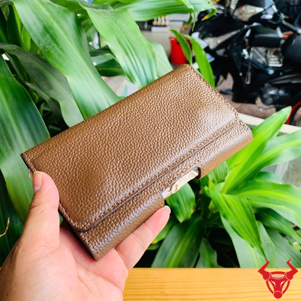 Bao Da Thắt Lưng OFAA19 - Bền Bỉ Với Thiết Kế Tiện Lợi Bao da thắt lưng OFAA19 bền bỉ, trưng bày với nền cây xanh và bàn gỗ.