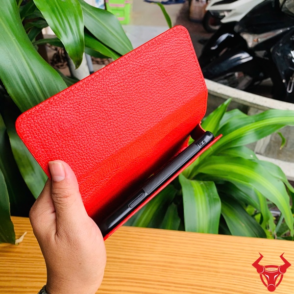 Bao Da Đeo Thắt Lưng Da Cá Sấu Màu Đỏ OFAA8 – Cao Cấp Thượng Hạng Bao da đeo thắt lưng da cá sấu màu đỏ OFAA8, cầm trên tay, nền lá xanh, logo đỏ góc phải.