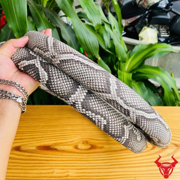 Đẳng Cấp Phong Cách Thượng Hạng Bọc vô lăng da trăn màu xám trắng họa tiết trăn, đường kính 33cm, đặt trên bàn gỗ, logo đỏ góc phải.