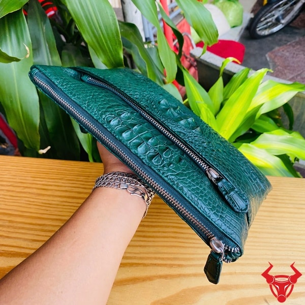 Clutch cầm tay da cá sấu cao cấp, màu xanh lá đầy phong cách.