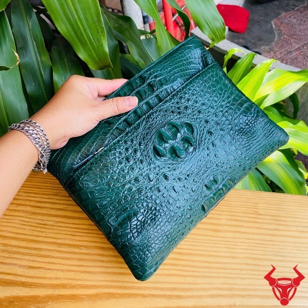 Clutch cầm tay da cá sấu xanh lá, thiết kế sang trọng.