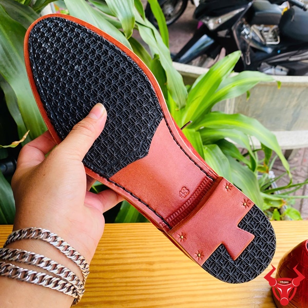 Giày Tây Đóng Thủ Công Da Bụng Cá Sấu GAA8 – Đẳng Cấp Cá Tính Thời Thượng Giày tây đóng thủ công da bụng cá sấu GAA8 màu đỏ, dây buộc xám, đặt trên bàn gỗ, nền lá xanh, logo đỏ góc phải.