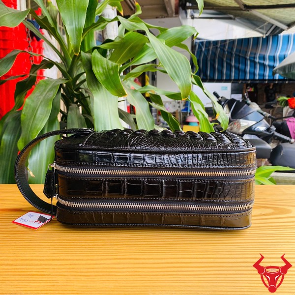 Clutch cá sấu gù đen CGA4 – Sự lựa chọn của người dẫn đầu Clutch da cá sấu đen CGA4 nổi bật giữa đám đông, thu hút ánh nhìn