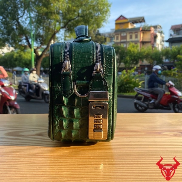 Chiếc túi golf da cá sấu màu xanh lá đậm nổi bật dưới ánh nắng tự nhiên.