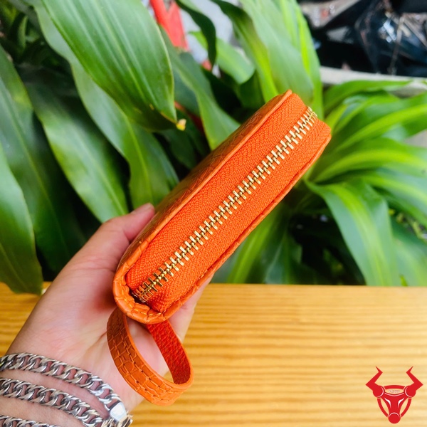 BUA8 – Ví cầm tay da thật sang trọng và tiện lợi Ví da bụng cá sấu màu cam rực rỡ dành cho người cá tính.