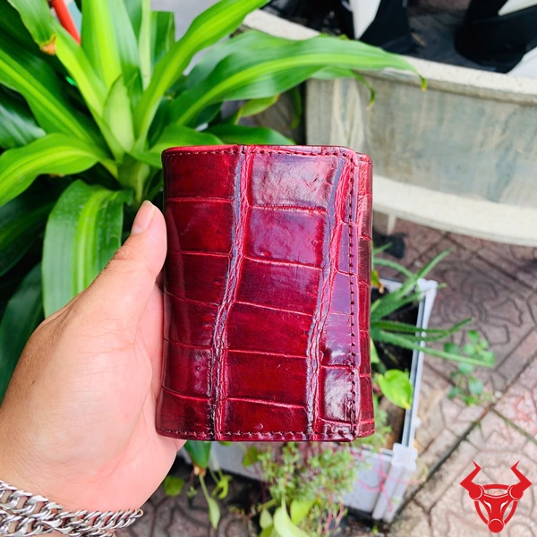 Ví Mini Da Bụng Cá Sấu VRA8 - Cao Cấp Cho Phái Đẹp Ví mini da bụng cá sấu VRA8 cao cấp với hoa văn độc đáo, đặt trên nền xanh lá.