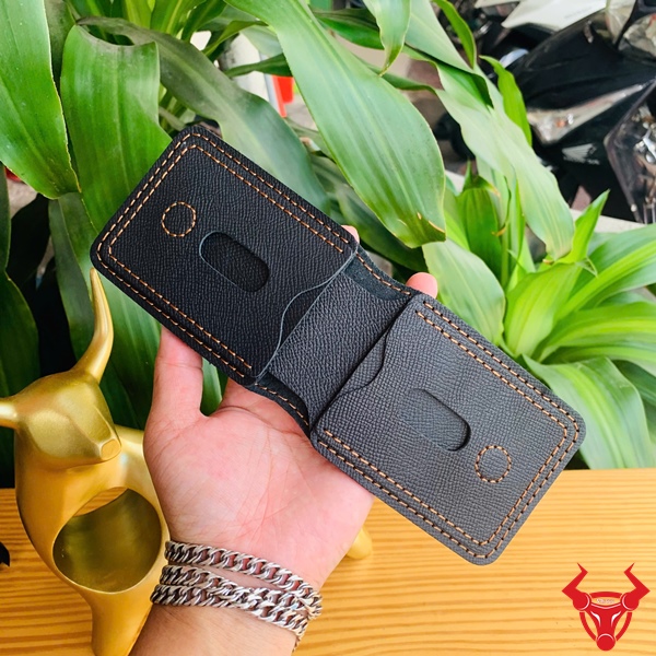 Ví nam handmade từ da EPSOM - Tinh tế và bền bỉ mỗi ngày Ví sen da bò phong cách tối giản đặt trước nền cây xanh.