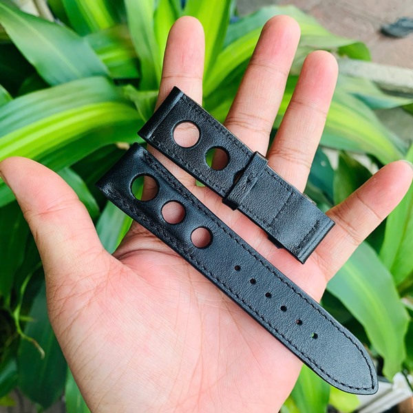 Thẩm mỹ vượt trội với dây da bò cá nhân hóa Hình ảnh dây đồng hồ da bò đen, lỗ thoát khí, thiết kế riêng, thẩm mỹ, trên tay với cây xanh.