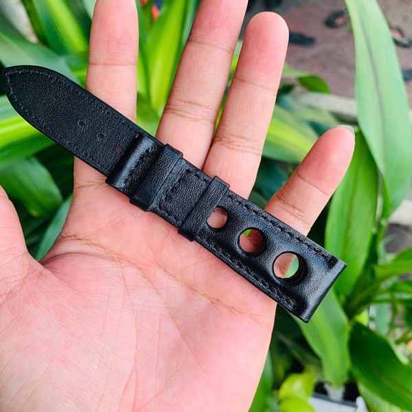 Thời trang cá nhân hóa với dây da bò Hình ảnh dây đồng hồ da bò đen, lỗ thoát khí, thiết kế riêng, thẩm mỹ, trên tay với cây xanh.