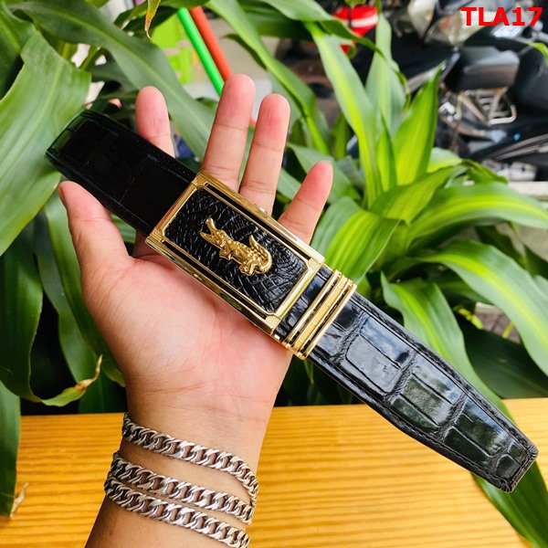 Thắt lưng FBA9B2 bền bỉ và chắc chắn Hình ảnh thắt lưng FBA9B2 da cá sấu, khóa vàng, bền bỉ, sang trọng, trên bàn gỗ với cây xanh phía sau.