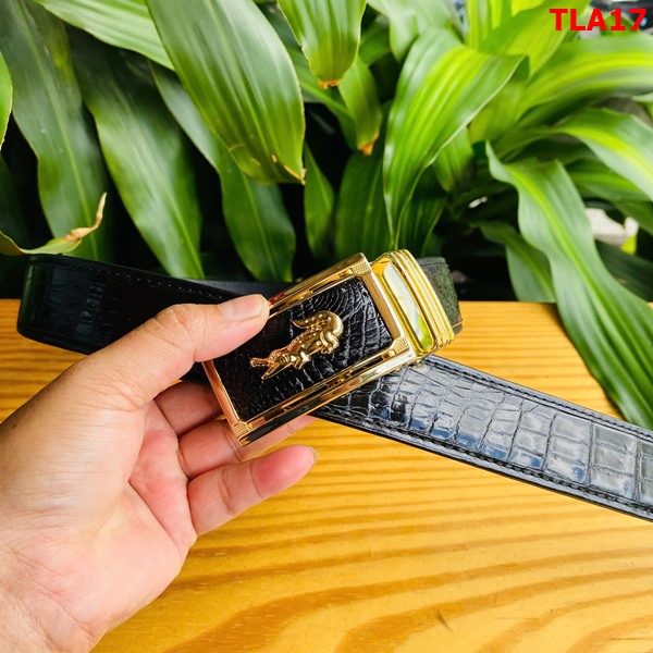 Thời trang bền vững với thắt lưng FBA9B2 Hình ảnh thắt lưng FBA9B2 da cá sấu, khóa vàng, bền bỉ, trên bàn gỗ với cây xanh.