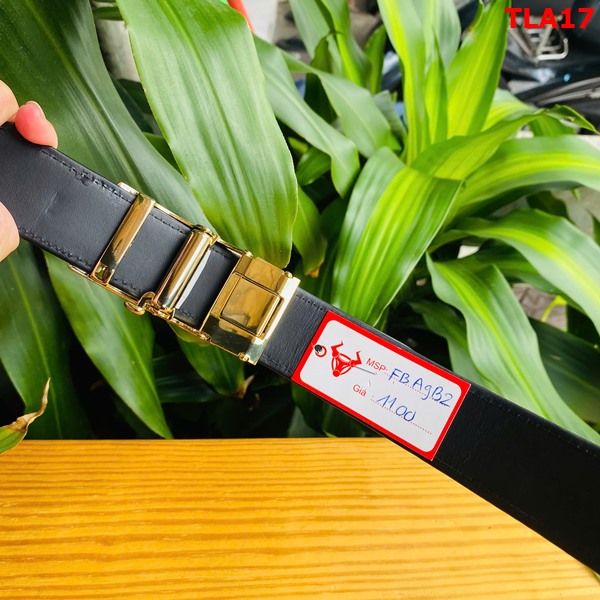 Thắt lưng FBA9B2 - chắc chắn và sang trọng Hình ảnh thắt lưng FBA9B2 da cá sấu, khóa mạ vàng, bền bỉ, trên bàn gỗ với cây xanh.