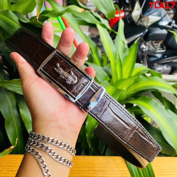 Đẳng cấp thời trang với thắt lưng da FBA9B2 Hình ảnh thắt lưng FBA9B2 da bụng cá sấu nâu đất, khóa kim loại, chắc chắn, trên bàn gỗ với cây xanh.