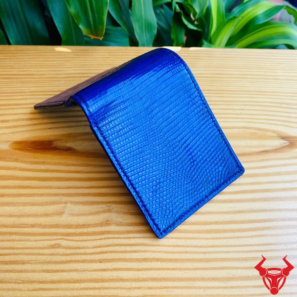 Ví Da Kỳ Đà VCA18 - Thời Trang Và Cá Tính Riêng Biệt Ví da kỳ đà VCA18 màu xanh đen, thiết kế độc đáo, thể hiện cá tính riêng trước nền lá xanh.