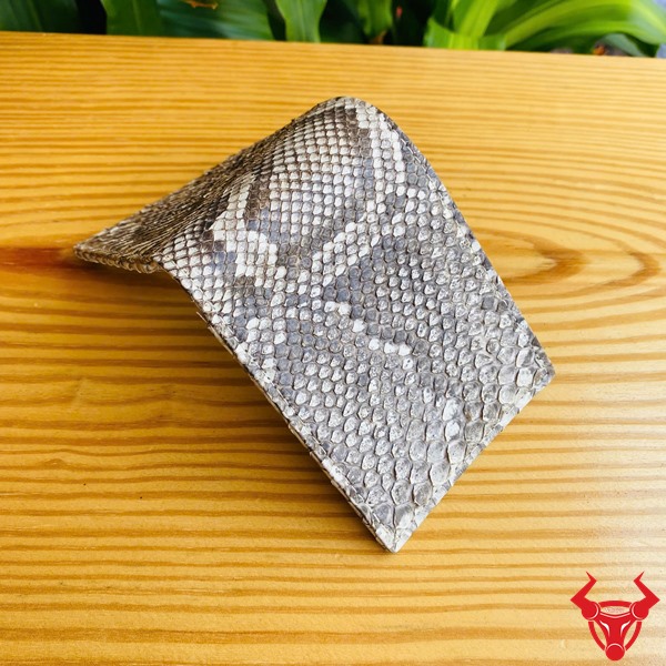 Ví Da Trăn VCA15 - Thời Trang, Cá Tính Riêng Và Phong Cách Biệt Lập Ví da trăn VCA15 màu trắng đen, thiết kế độc đáo, thể hiện cá tính và phong cách trước nền lá xanh.