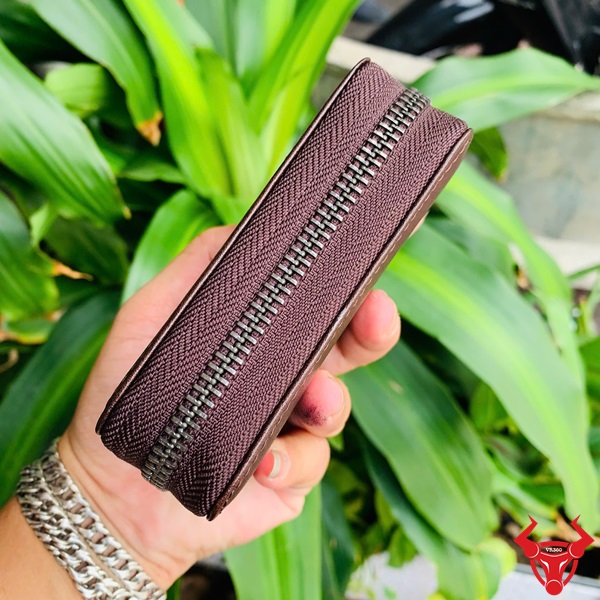Ví VDB61 – Sự Lựa Chọn Thông Minh Cho Người Hiện Đại Một người đang cầm ví namecard da bò màu nâu đất.