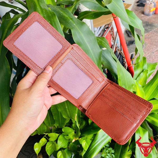Ví Ngang Da Cá Sấu Phối Màu Thời Trang Độc Nhất Ví ngang da cá sấu phối màu trắng và nâu, tay cầm, nền lá xanh và xe máy.