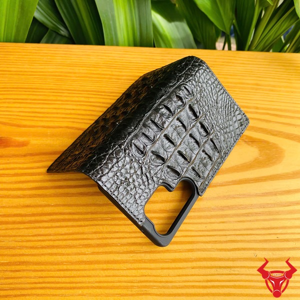 Phụ Kiện Cao Cấp Bền Bỉ Chắc Chắn Sang Trọng Bao Bảo Vệ S25 Ultra Da Gai Cá Sấu Đen Hình ảnh sản phẩm bao da S25 Ultra da cá sấu màu đen, cầm trên tay trước nền lá cây, thể hiện sự cao cấp và chắc chắn.