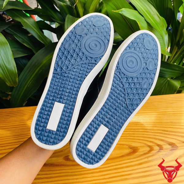 Sang Trọng Cao Cấp: Giày Thể Thao GCS25 Năng Động Thời Trang Da Cá Sấu Ảnh đôi giày da cá sấu đen thể thao sang trọng, trên bàn với nền thực vật xanh và logo.