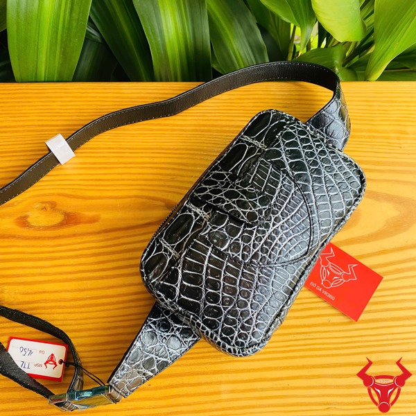 Túi Đeo Bụng Da Cá Sấu TTL06 Đen Thời Trang Năng Động Đa Năng Ảnh túi đeo bụng TTL06 da cá sấu đen, đặt trên bàn với lá xanh, nhấn mạnh sự thời trang và năng động.