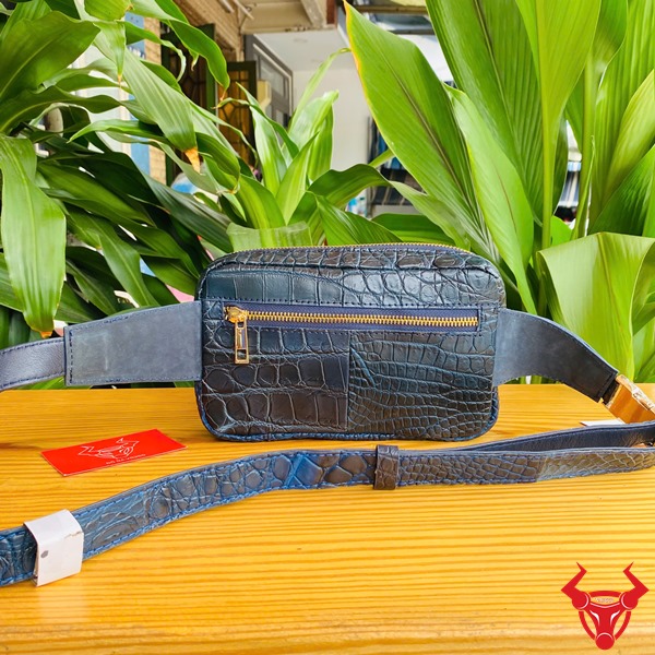 Túi Đeo Bụng Cá Sấu TTL06 Xanh Navy Năng Động Thời Trang Đa Năng Ảnh túi đeo bụng TTL06 da cá sấu xanh navy, đặt trên bàn với nền lá, nhấn mạnh sự năng động và đa năng.