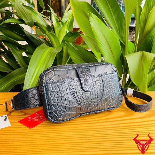 Túi Đeo Bụng Da Cá Sấu TTL06 Xanh Navy Năng Động Đa Dụng Thời Trang Ảnh túi đeo bụng TTL06 da cá sấu xanh navy, đặt trên bàn với lá xanh, nhấn mạnh sự năng động.