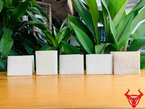 Da Bụng Cá Sấu VSAA8 Trắng – Phụ Kiện Thời Trang Cao Cấp Đẳng Cấp Ảnh ví mini da cá sấu trắng VGA8 hai mặt, được cầm với vòng tay bạc.