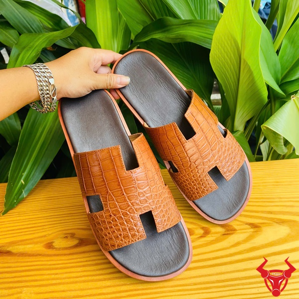 Dép êm chân bền đẹp, thời trang cao cấp cho size 41 hiện đại. Hình ảnh dép chữ H da cá sấu DJA8 màu nâu nhạt size 41 với nền lá xanh.