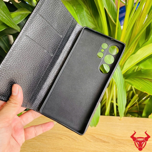 Phong Cách Cao Cấp Từ Bao Da Cá Sấu Đen Samsung S25 Bao da điện thoại Samsung S25 da cá sấu đen, cầm tay trước lá xanh, biểu tượng thời trang cao cấp.